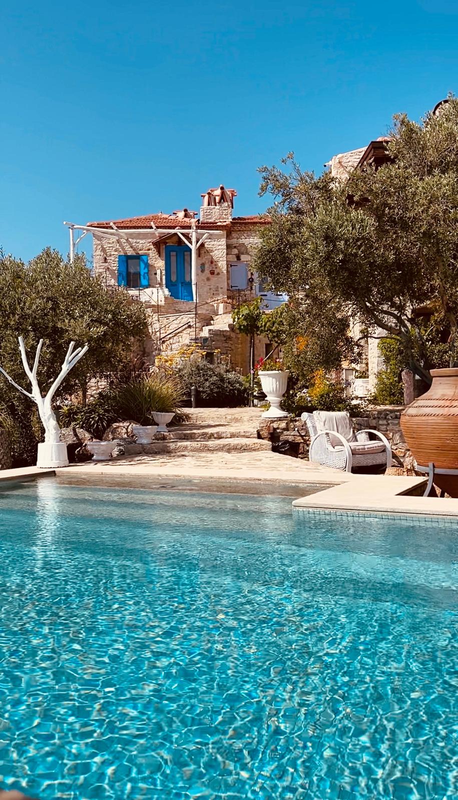 Casa egea in pietra con porte blu, ulivi e piscina sulla penisola di Datça