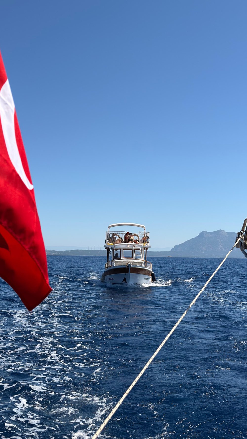 La barca privata con la bandiera turca naviga tra le baie di Datça