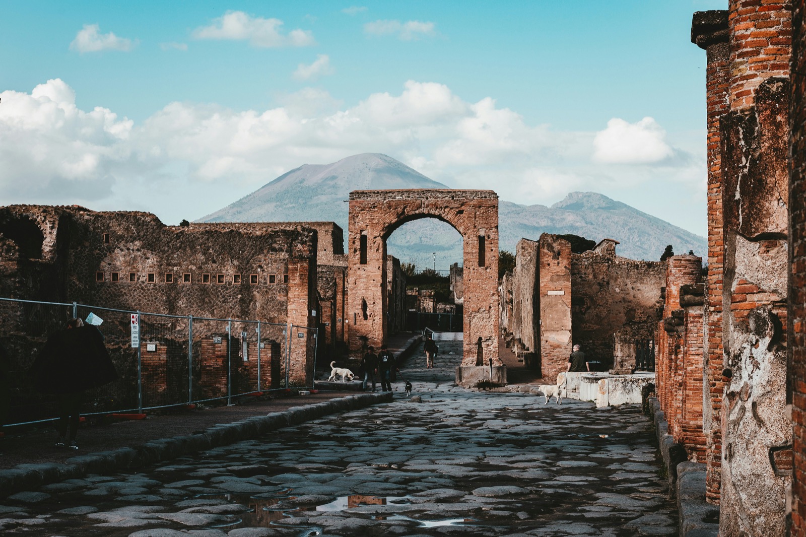 Strada antica di Pompei con arco romano e Vesuvio sullo sfondo