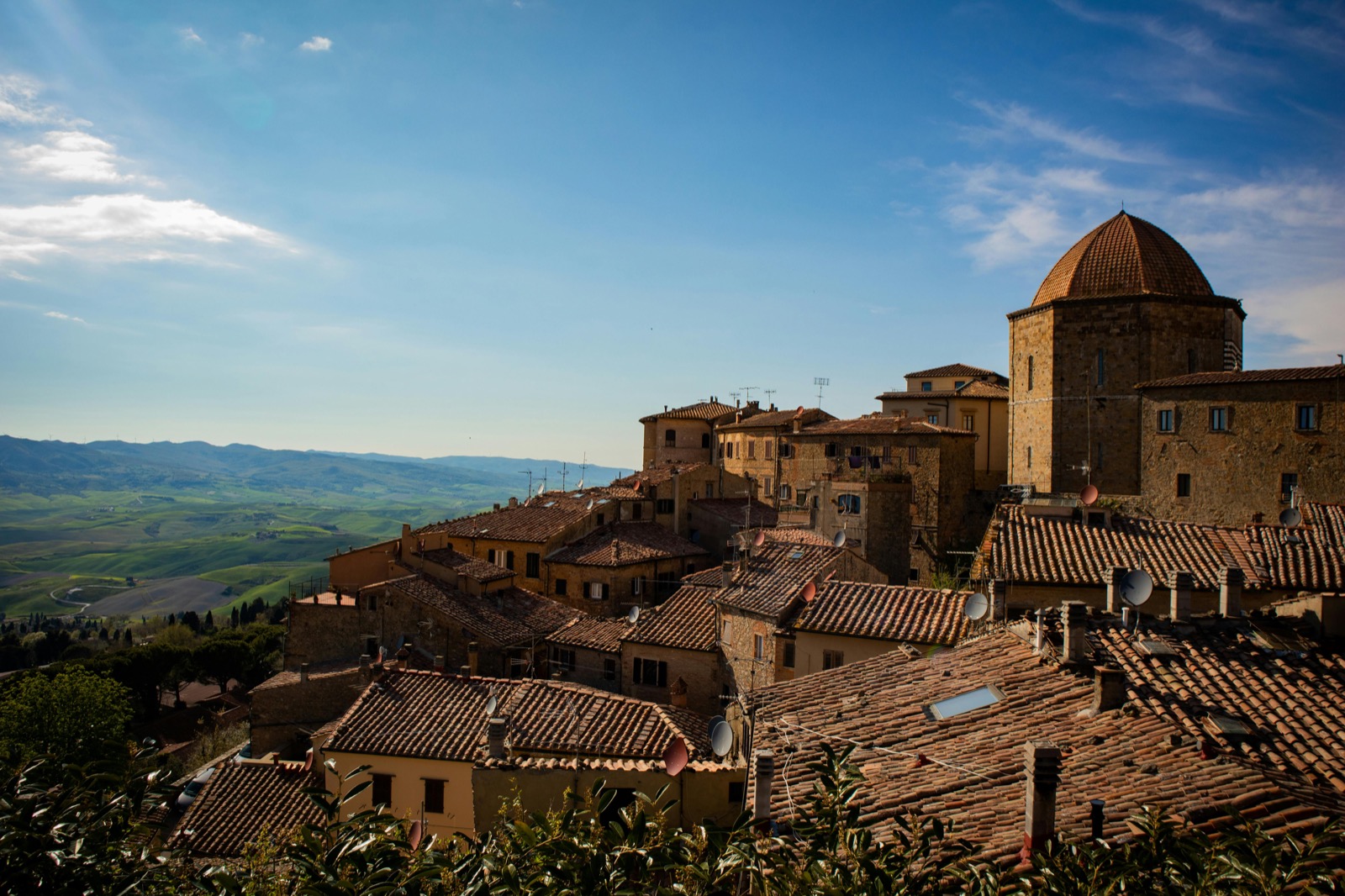 Borgo medievale di Volterra con tetti rossi e colline toscane